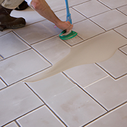 Man cleaning a tiled floor before sealing